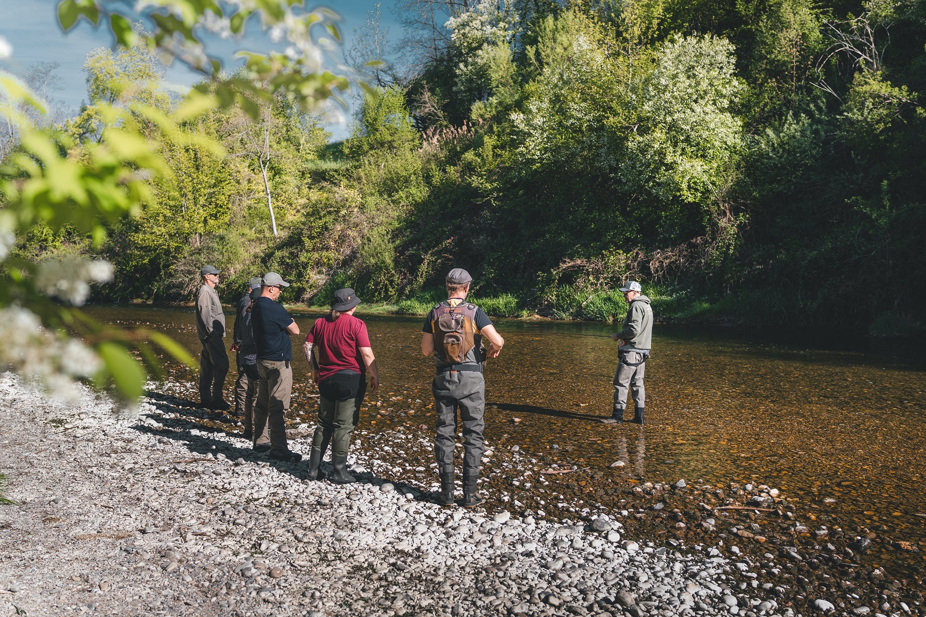 Rolf Bünter bespricht mit Fortgeschrittenen-Teilnehmern eine Fliegenmontage am Fluss – fortgeschrittene Detailarbeit mit Flyfishing Guide Service. Flyfishing Guide Service, Flyfish Bünti, Fliegenfischen mit Rolf Bünter, Fliegenfischen Schweiz, Fliegenmontage Detail, Fortgeschrittenen-Coaching, Vorfach-Tuning, Fliegenwahl, Spezialknoten, Wurfweste, Brustpack, Stammrevier Töss, Fortgeschrittene Theorie, Fliegen-Bestimmung, Insektenkunde, Schweizer Fluss, Detail-Coaching, Fortgeschrittenenkurs
